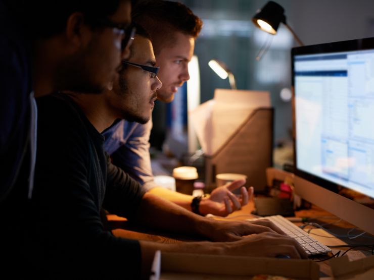 Three man lookin at a computer screen